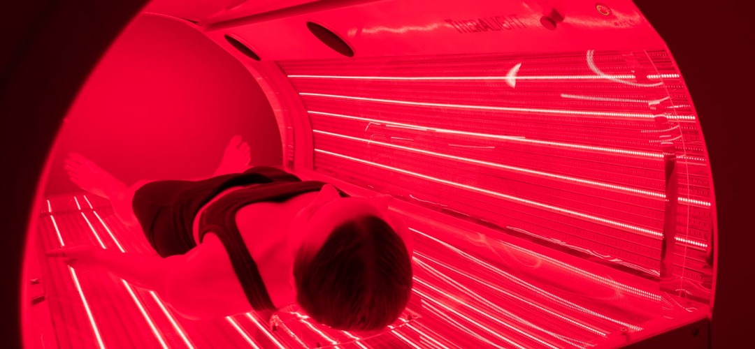 a client using theralight (red light therapy) at thrive drip spa to relieve stress, inflammation, pain and boost wellness